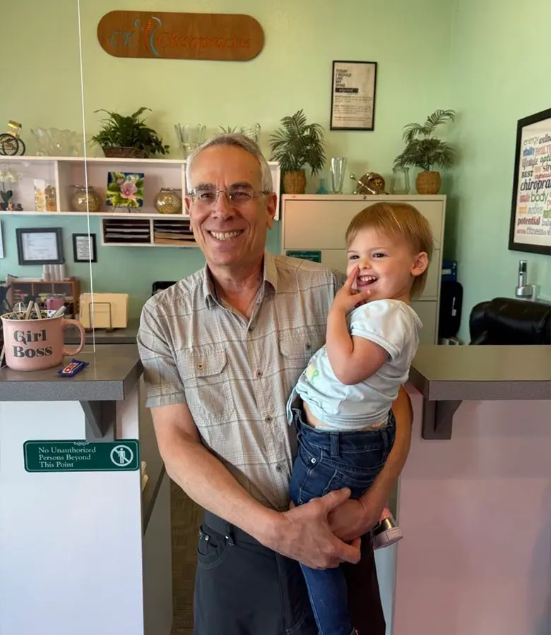 Dr. Scott Siegel with a smiling young patient at CK Chiropractic Office in Silverdale, WA