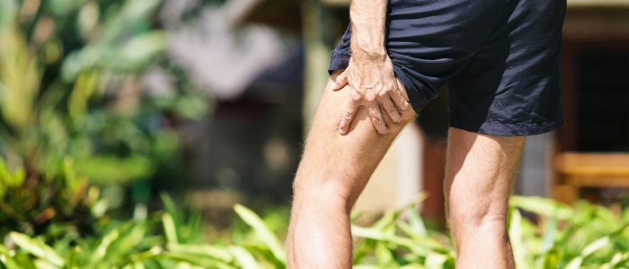 A person holding their leg in pain.